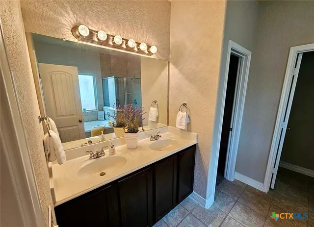 a bathroom with a double vanity sink and mirror