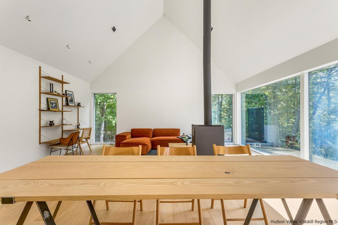 261 Blackhead Mountain Round Top, NY 12473 - Photo 14 of 34 a bedroom with a bed and large windows
