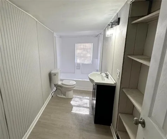 a bathroom with a sink toilet and mirror