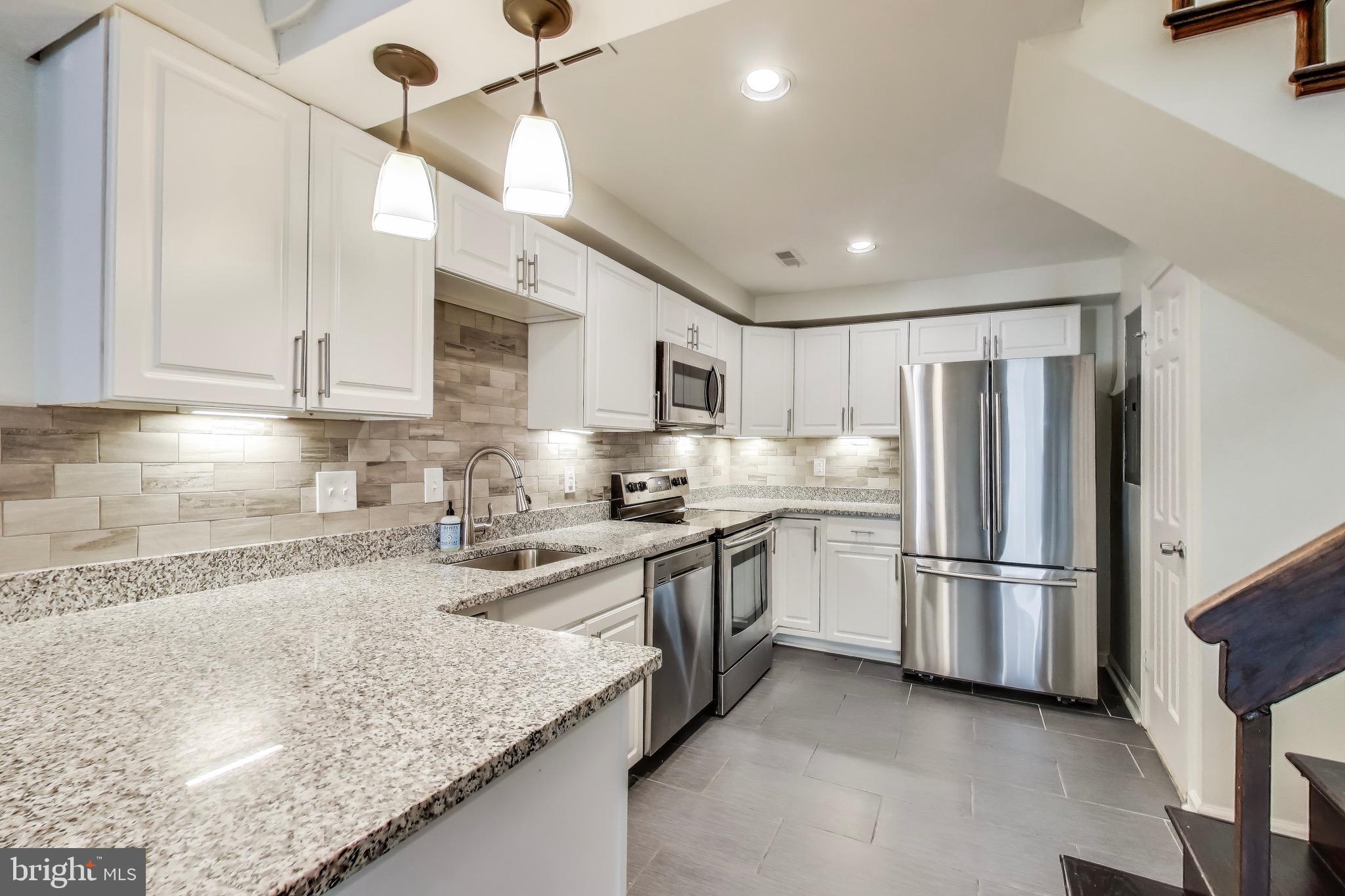 1625 S Street Northwest, Unit 1 Washington, DC 20009 - Photo 3 of 13 a kitchen with stainless steel appliances granite countertop a refrigerator a sink and a stove