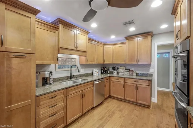 a kitchen with a sink stainless steel appliances cabinets and a counter top space