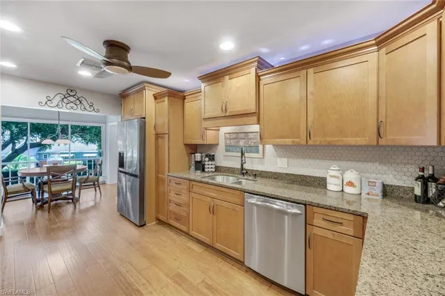a kitchen with a sink appliances cabinets and furniture