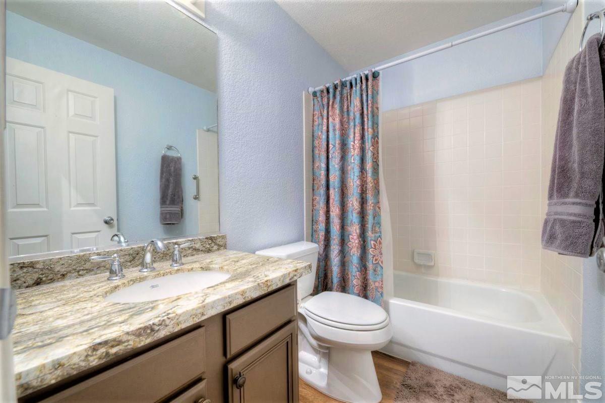 15135 Sylvester Road Reno, NV 89521 - Photo 13 of 34 a bathroom with a granite countertop sink toilet and shower