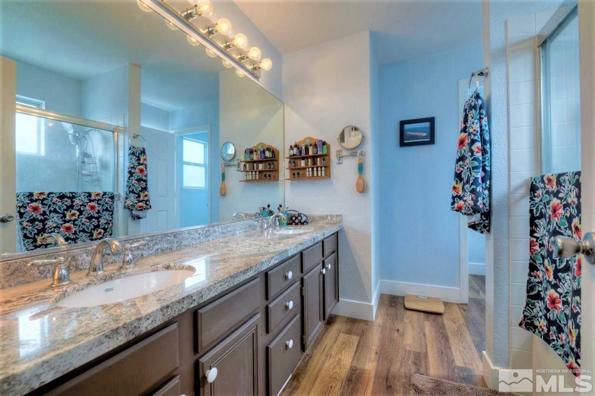 15135 Sylvester Road Reno, NV 89521 - Photo 17 of 34 a bathroom with a granite countertop sink a large mirror and a shower
