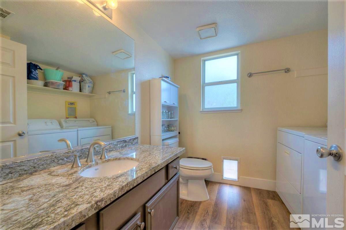 15135 Sylvester Road Reno, NV 89521 - Photo 18 of 34 a bathroom with a granite countertop sink a toilet and a large mirror