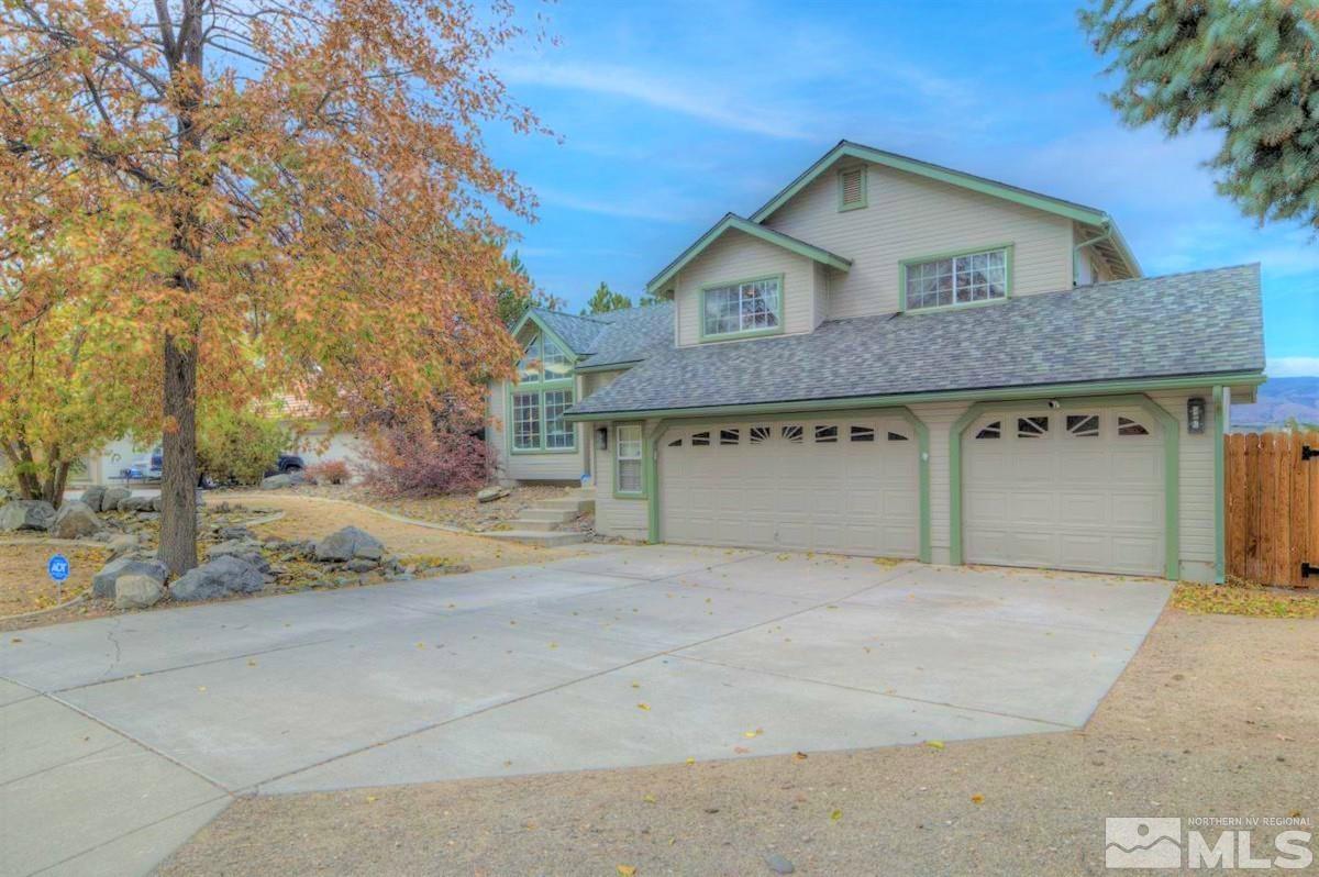 15135 Sylvester Road Reno, NV 89521 - Photo 3 of 34 a front view of a house with a yard and garage