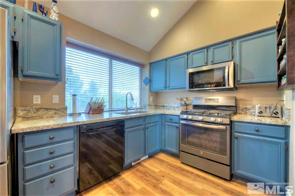 15135 Sylvester Road Reno, NV 89521 - Photo 9 of 34 a kitchen with granite countertop wooden cabinets stainless steel appliances and a window