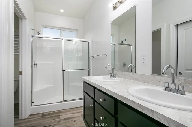 a bathroom with a double vanity sink mirror and shower