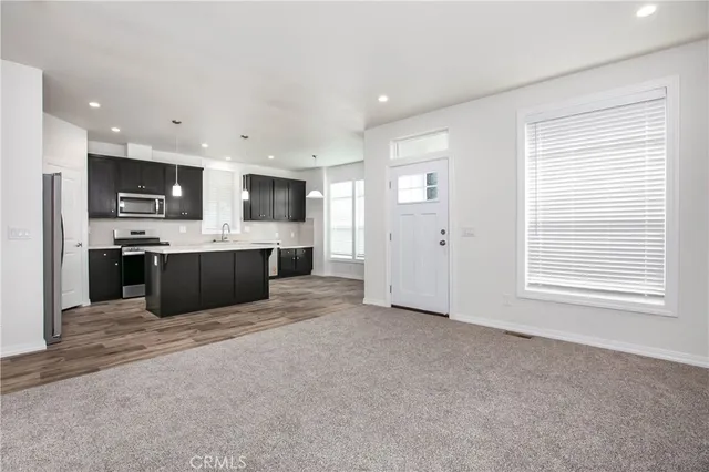 a large kitchen with stainless steel appliances kitchen island a large counter top and a fireplace