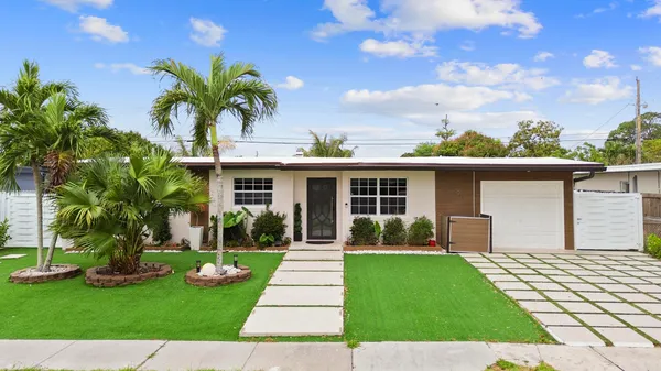front view of a house with a yard and potted plants