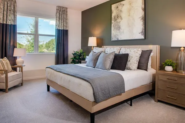 a bed sitting in a bedroom next to a window