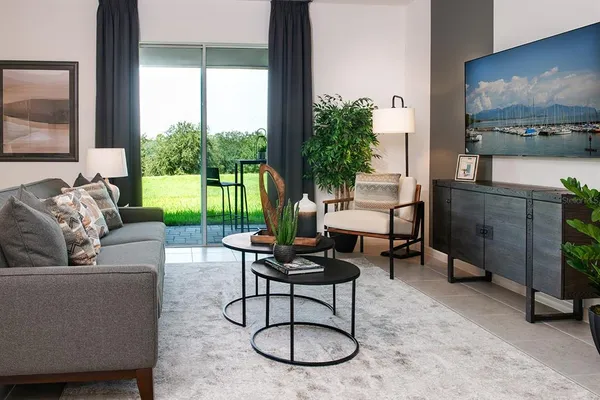 a living room with furniture potted plant and a large window