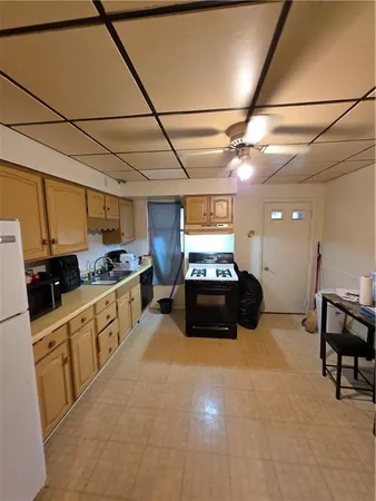 a large kitchen with kitchen island a counter top space a sink stainless steel appliances and cabinets