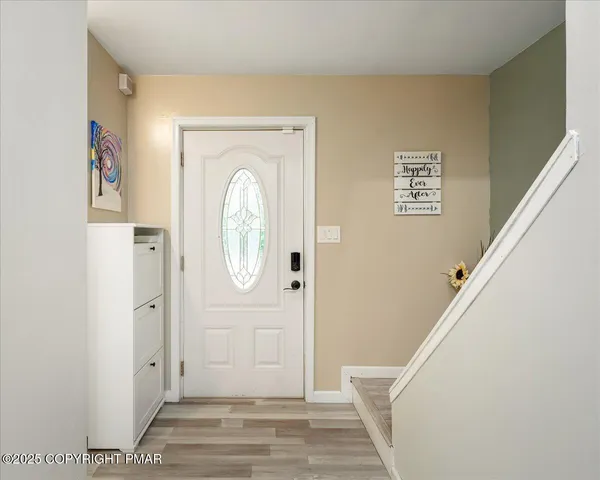 a view of a hallway with entryway wooden floor and front door