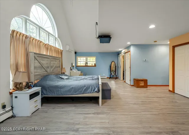 a spacious bedroom with a bed and a dresser