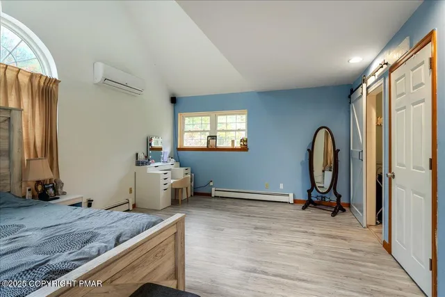 a bathroom with a granite countertop toilet a sink a mirror and a window