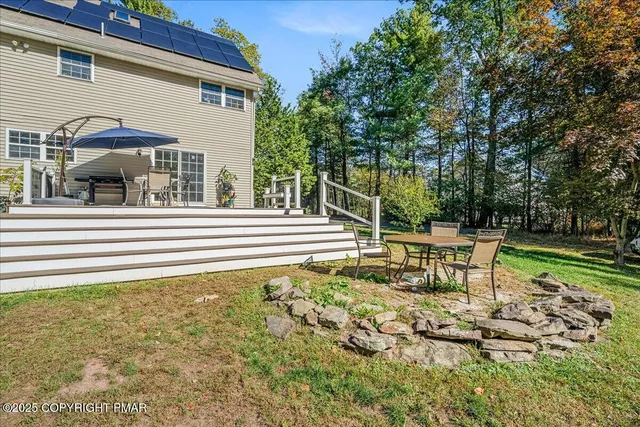 a view of a house with backyard and sitting area