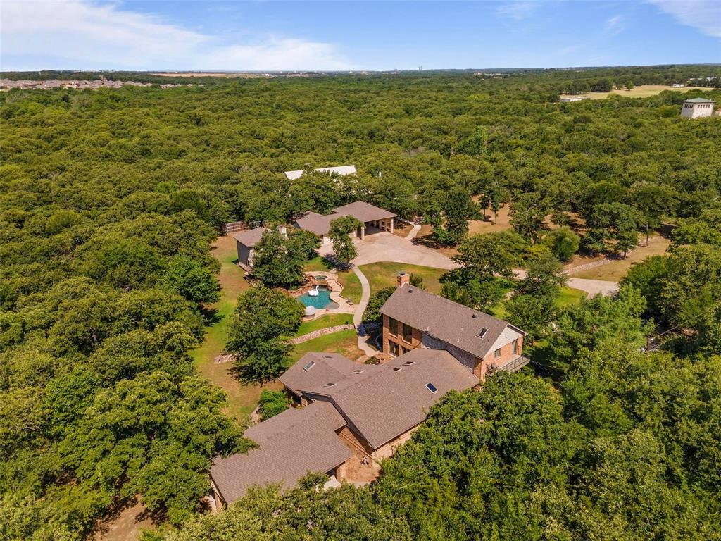Lush canopy of trees surround the property on this 2 acre lakefront compound.