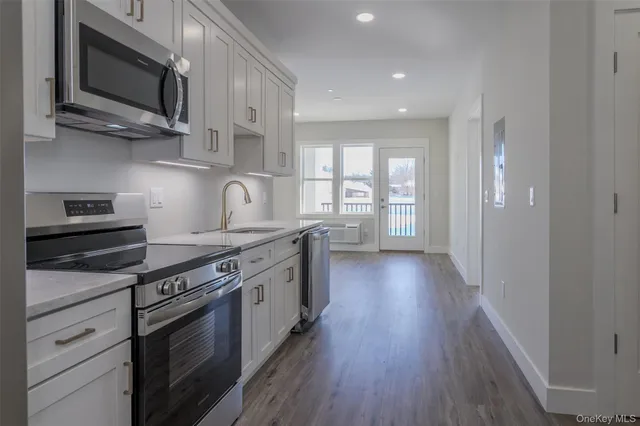 a kitchen with stainless steel appliances granite countertop wooden cabinets stove top oven and sink