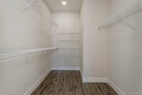 a view of walk in closet with wooden floor