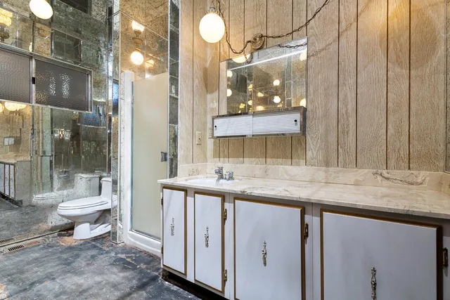 a bathroom with a granite countertop sink a toilet and a mirror