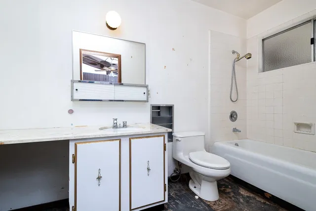 a bathroom with a toilet sink vanity tub and shower