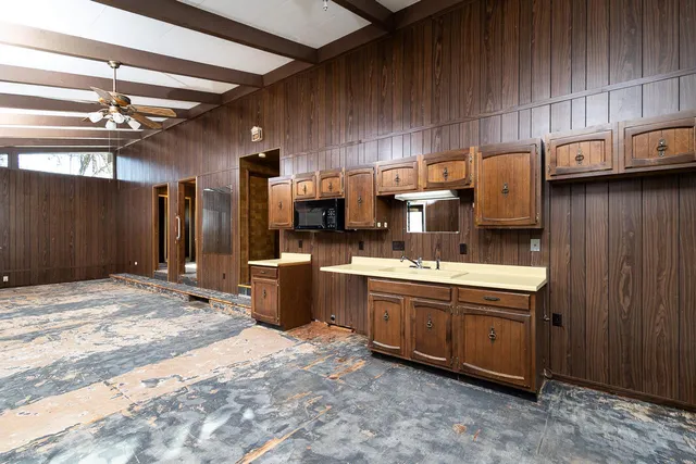 a kitchen with kitchen island granite countertop a sink stove and refrigerator