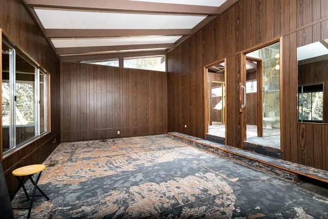 a bedroom with a bed and large windows