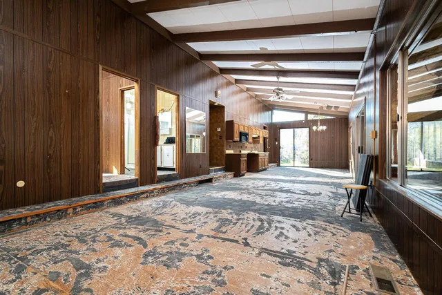 a view of a hallway with wooden floor and windows