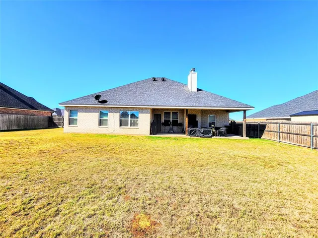 a view of swimming pool with lawn chairs under an umbrella