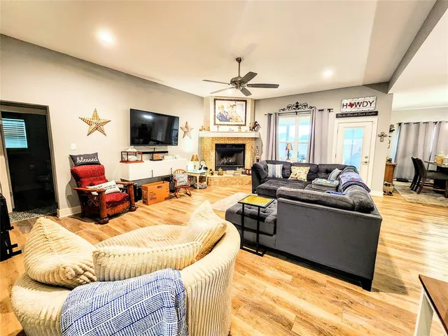 a living room with furniture kitchen view and a flat screen tv
