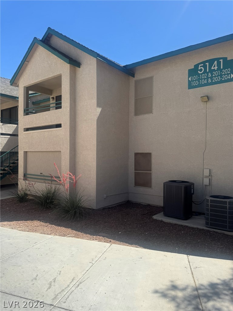 A well-maintained stucco facade with a covered balcony offers inviting outdoor living space.