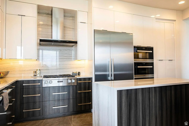 1500 Split Rock, Unit 150 Ivins, UT 84738 - Photo 11 of 14 Gourmet kitchen featuring a gas range, stainless steel appliances, built-in double ovens, two-tone cabinetry with white upper cabinets and wood-finish lower cabinets, and stone countertops