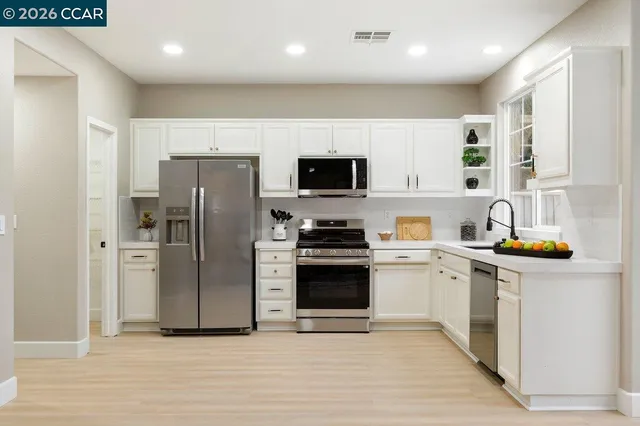 a kitchen with stainless steel appliances a refrigerator sink and microwave