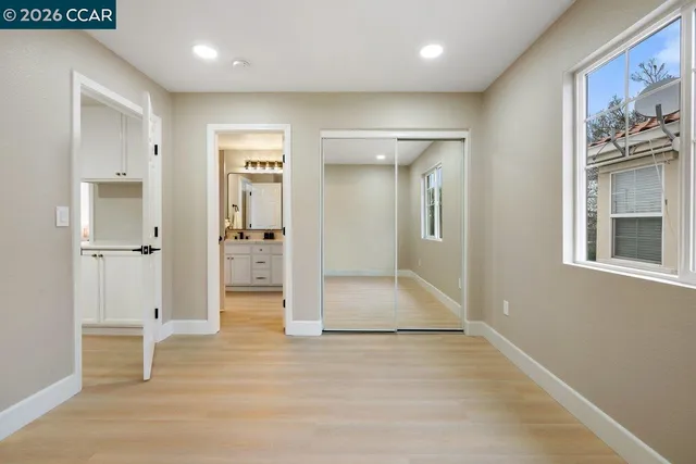 a view of a hallway with wooden floor and a living room