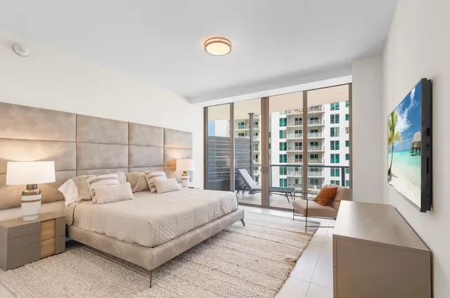 a bedroom with a large bed and a large window