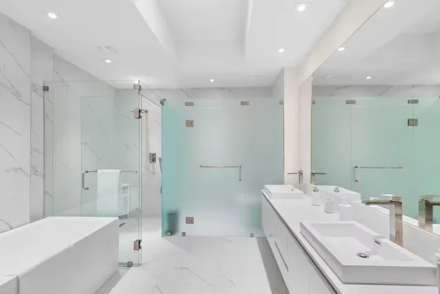 a bathroom with a tub sink shower and mirror