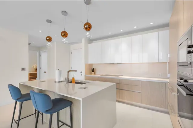 a kitchen with a sink and chairs