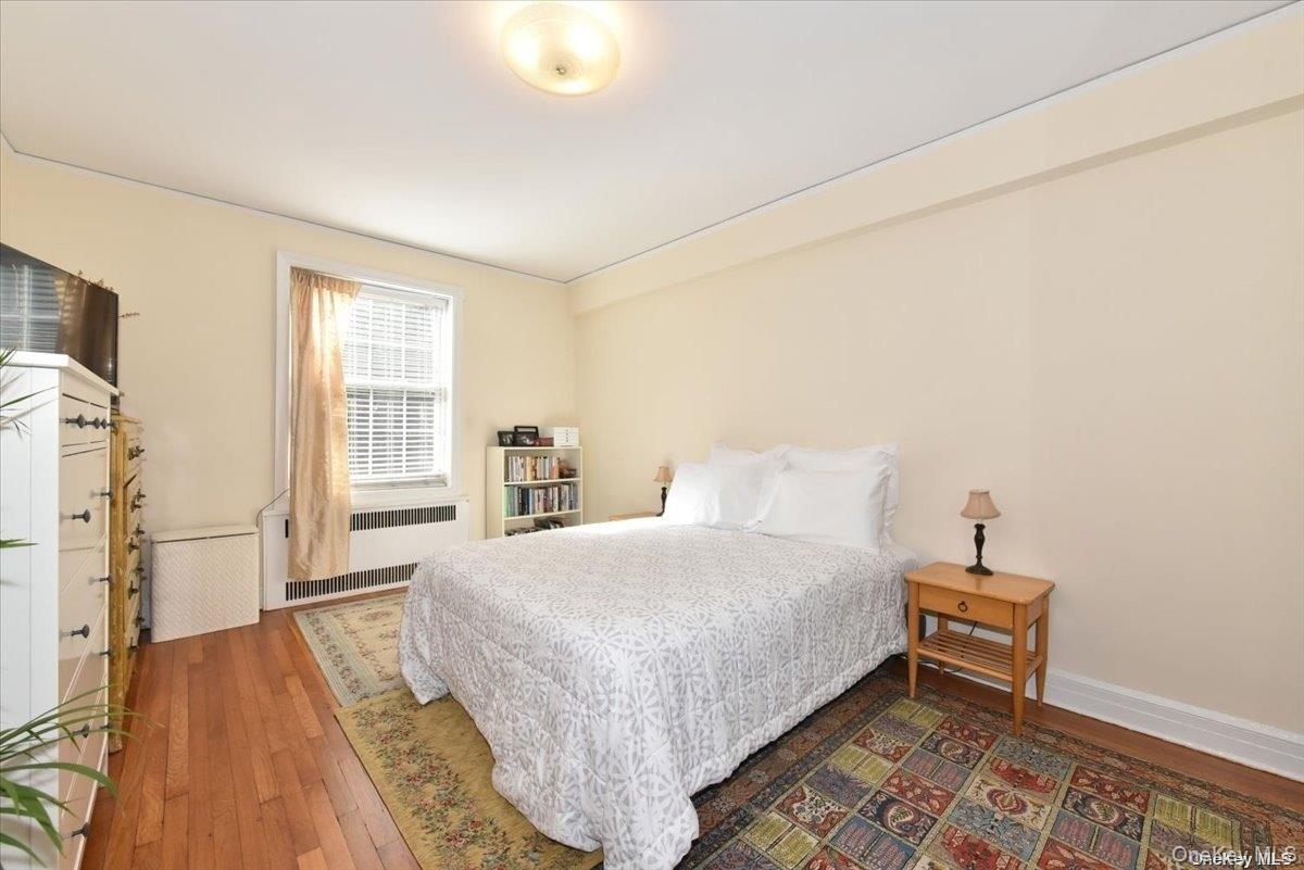 175-06 Devonshire Road, Unit 1J Queens, NY 11432 - Photo 12 of 20 a bedroom with a bed and a window