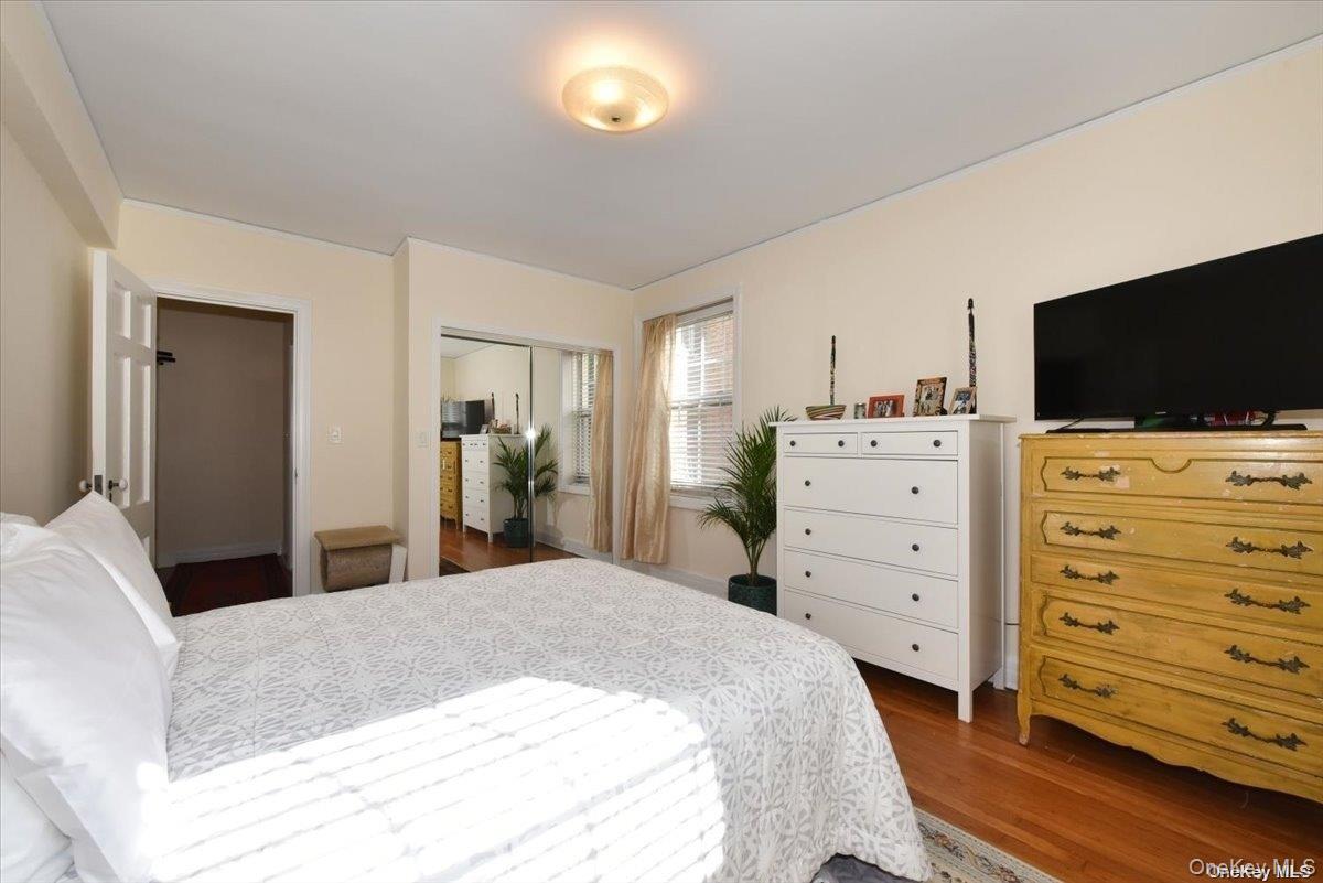 175-06 Devonshire Road, Unit 1J Queens, NY 11432 - Photo 13 of 20 a bedroom with a bed and a flat screen tv