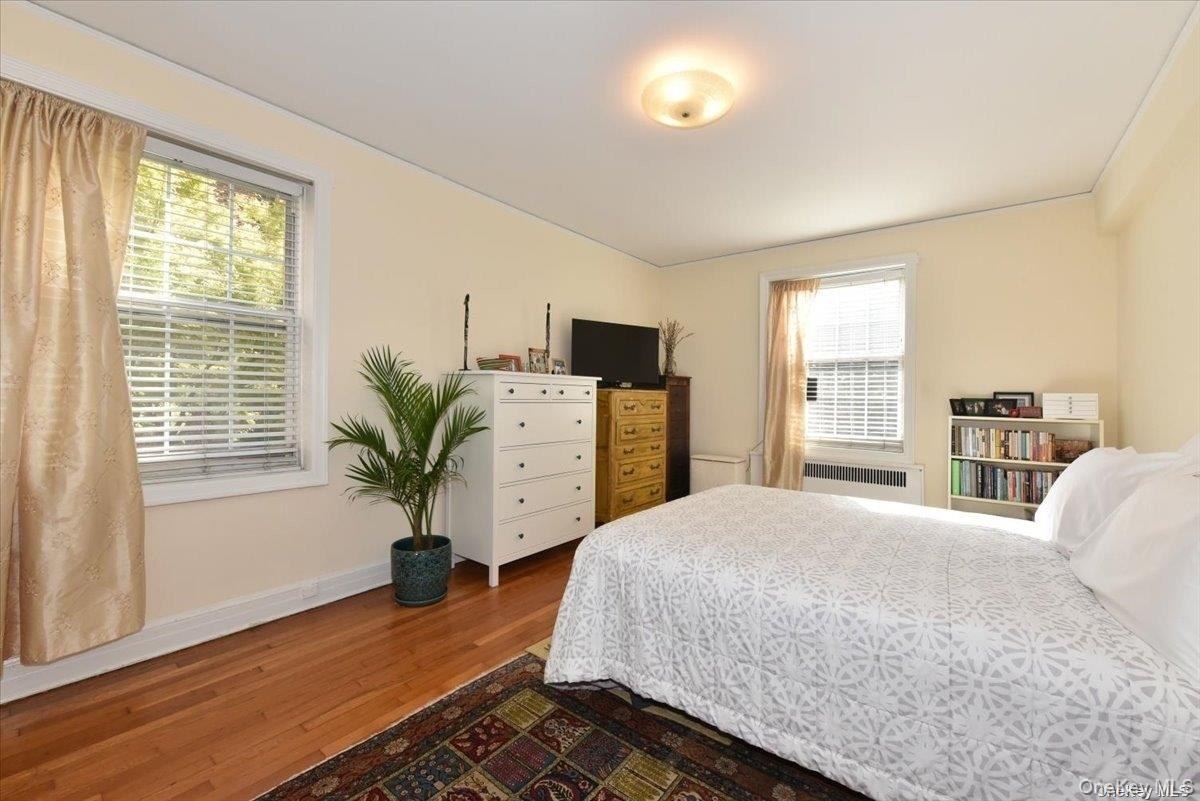 175-06 Devonshire Road, Unit 1J Queens, NY 11432 - Photo 14 of 20 a bedroom with a bed and large windows