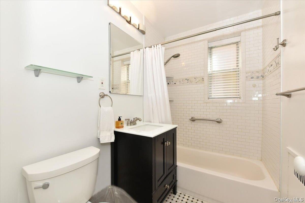 175-06 Devonshire Road, Unit 1J Queens, NY 11432 - Photo 15 of 20 a bathroom with a sink a toilet and shower