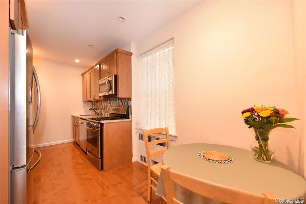 175-06 Devonshire Road, Unit 1J Queens, NY 11432 - Photo 8 of 20 a kitchen with a sink appliances and cabinets