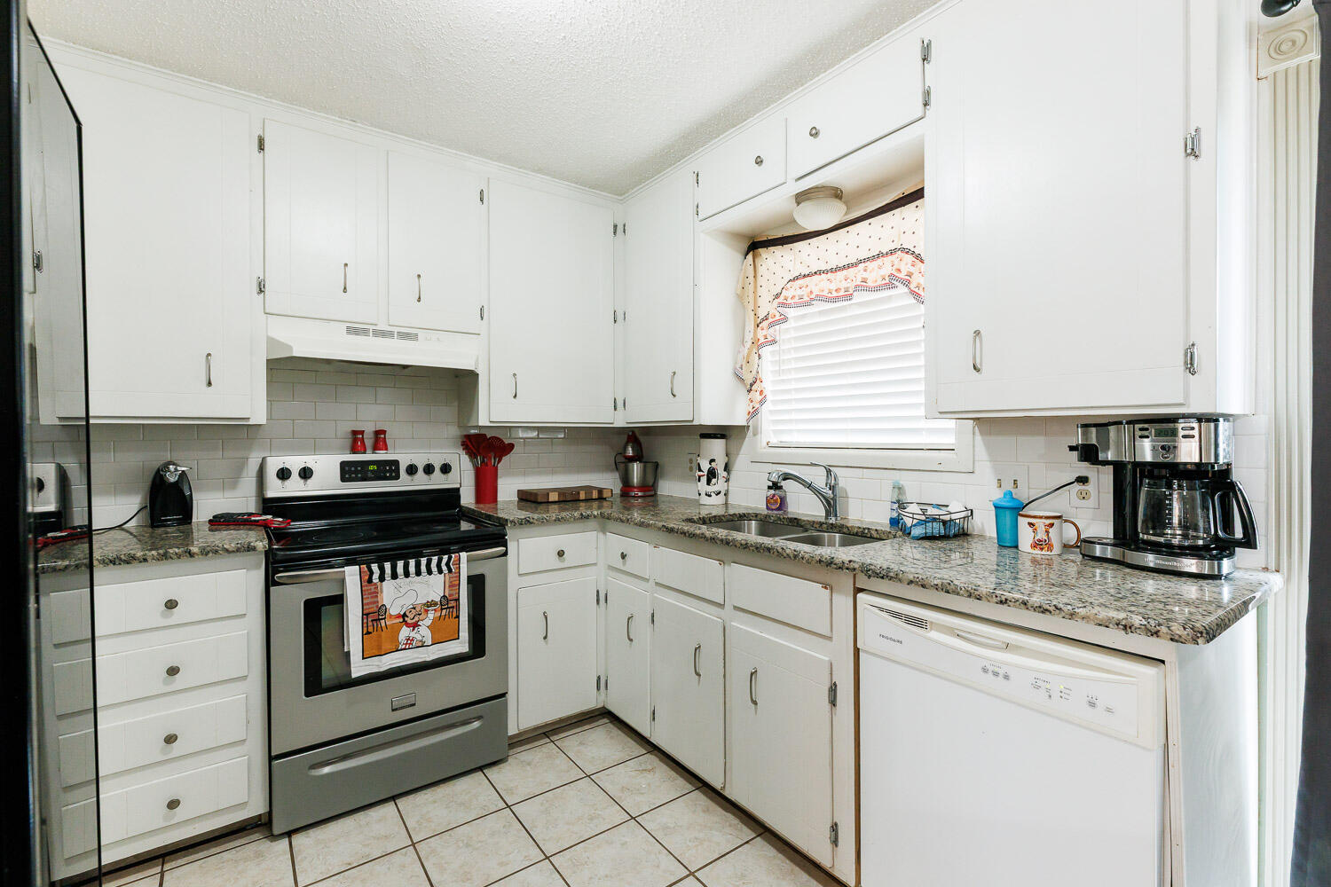 1907 73rd Street Lubbock, TX 79423 - Photo 3 of 41 a kitchen with granite countertop white cabinets and white appliances