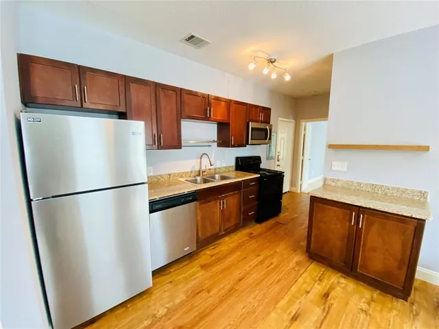 a kitchen with stainless steel appliances a refrigerator and a sink