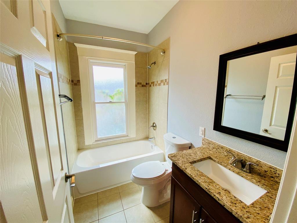 4318 Junius Street, Unit 3 Dallas, TX 75246 - Photo 13 of 29 a bathroom with a granite countertop sink toilet a mirror and bathtub
