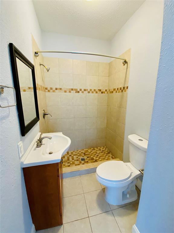 4318 Junius Street, Unit 3 Dallas, TX 75246 - Photo 24 of 29 a bathroom with a sink a toilet a mirror and shower