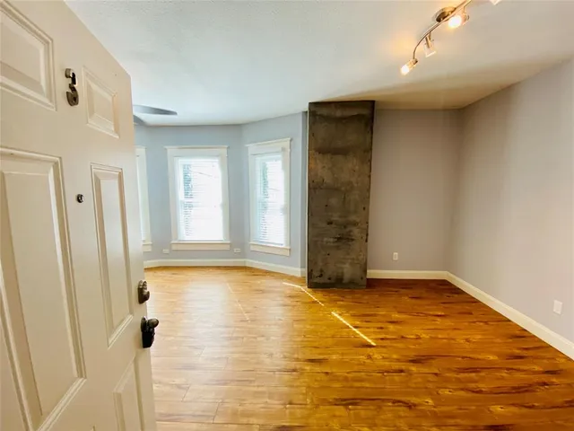 a view of an empty room with window and closet area