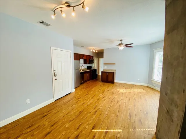 a view of empty room with wooden floor