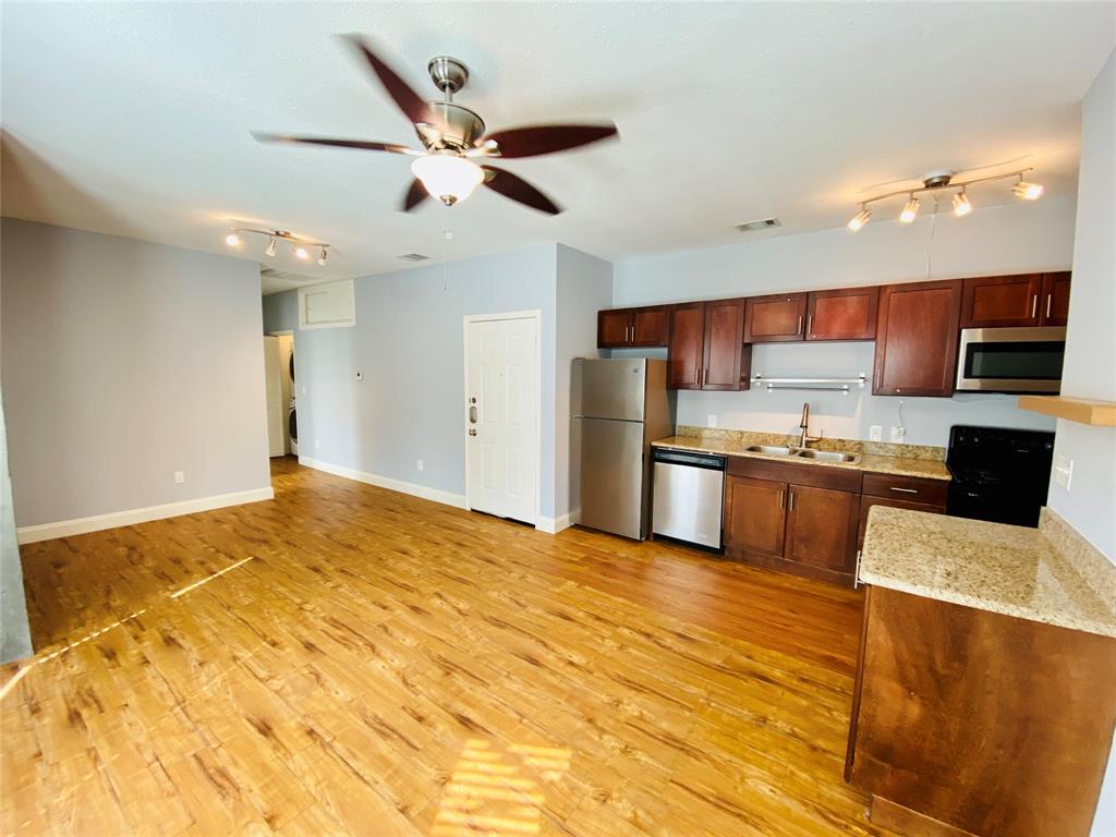 4318 Junius Street, Unit 3 Dallas, TX 75246 - Photo 10 of 29 a kitchen with stainless steel appliances kitchen island granite countertop a refrigerator and a stove top oven